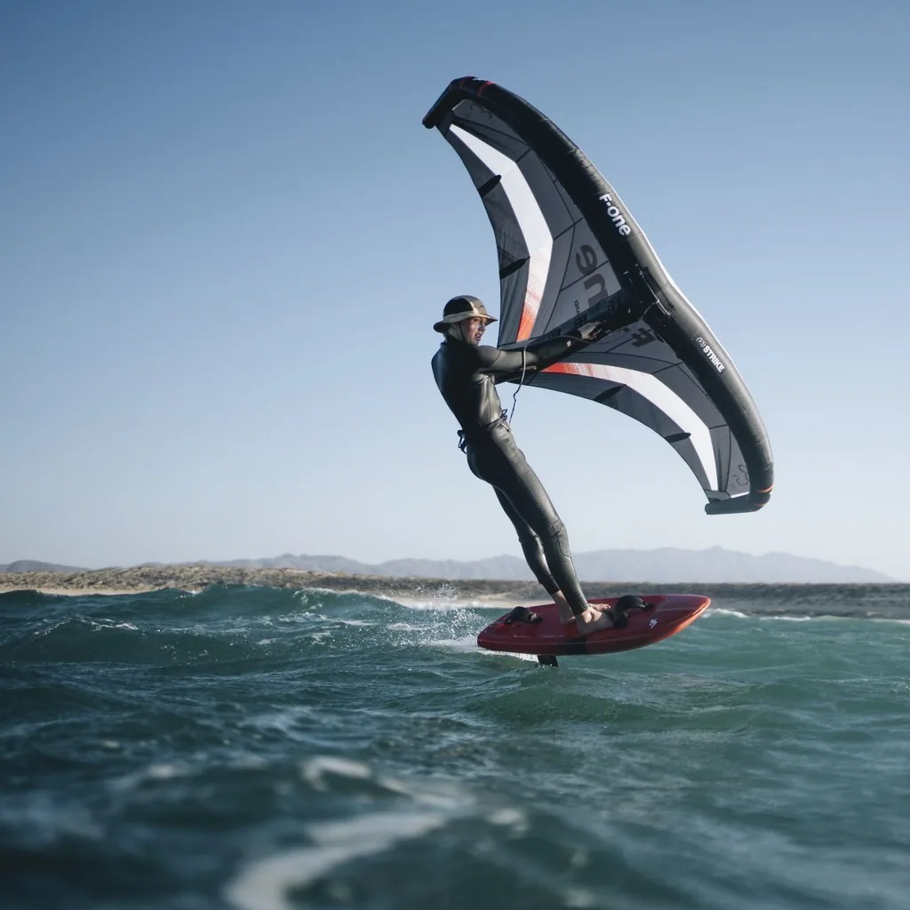 Rider en wingfoil avec F-One Strike V5 sur mer calme