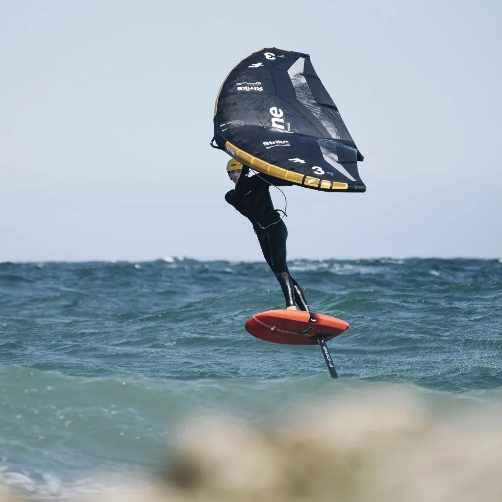 Rider en wingfoil avec F-One Strike V5 sur mer agitée