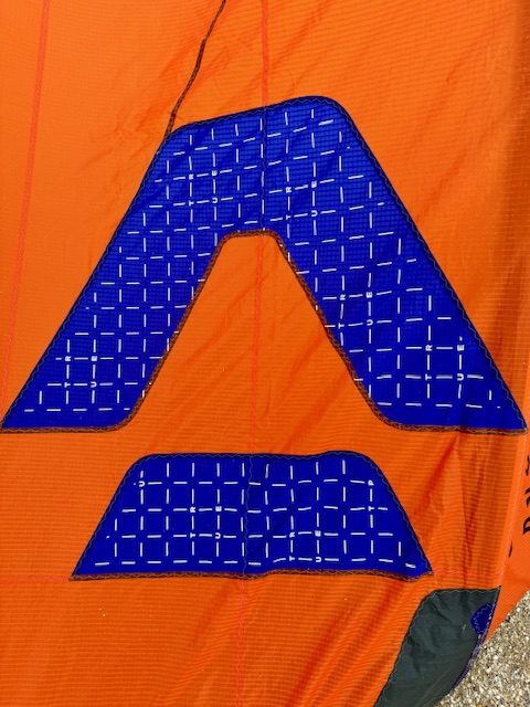 Dark blue DUOTONE brand logo on an orange kite.